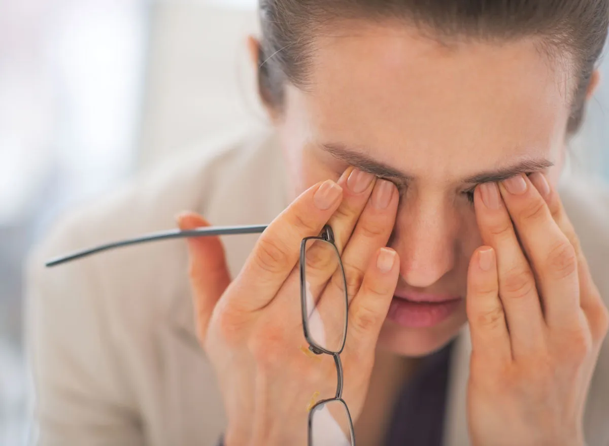 Tired stressed woman rubbing eyes