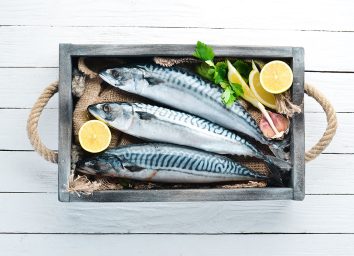 top view of raw mackerel on white wooden background