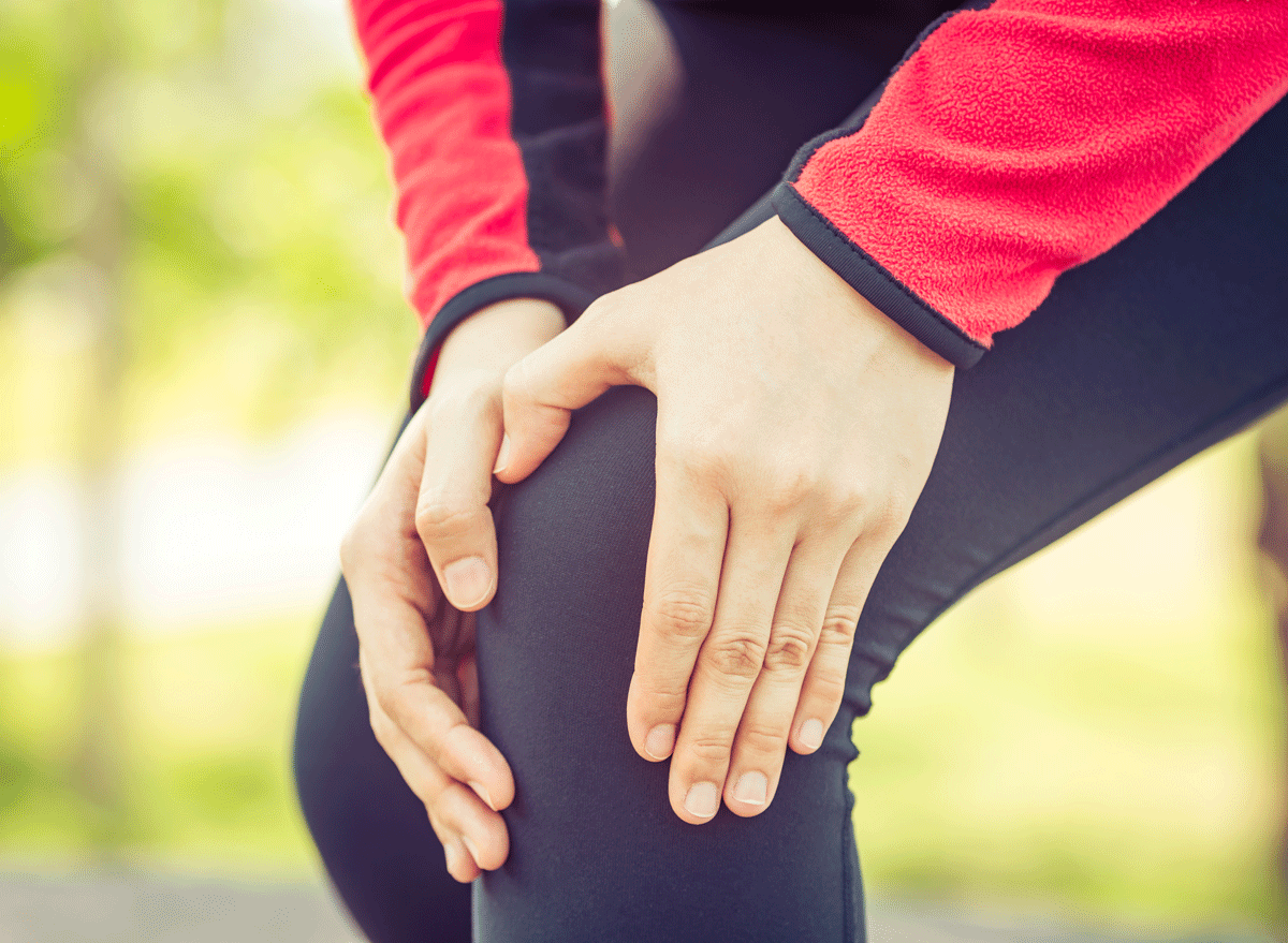 woman with arthritis holding knee