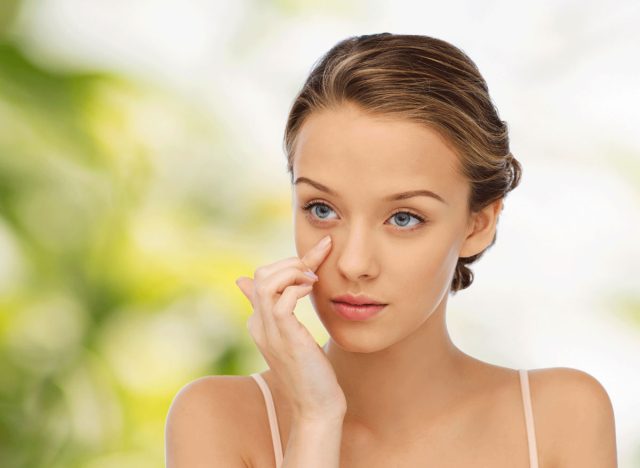 woman putting on eye cream