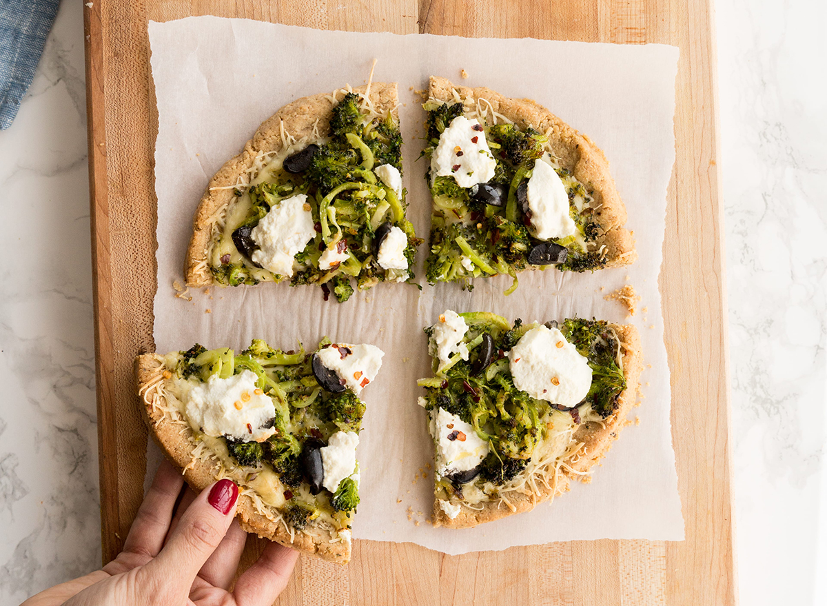 spiralizált brokkoli és olíva bianca fehér pizza viaszpapíron készen áll a tálalásra