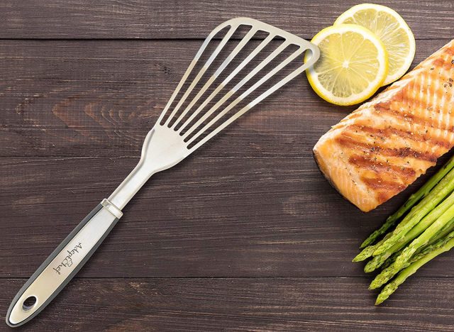 adept chef fish spatula with salmon and asparagus on a wooden board