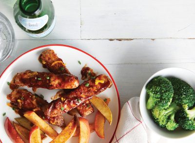 boneless barbecue ribs and broccoli on plates on wooden background