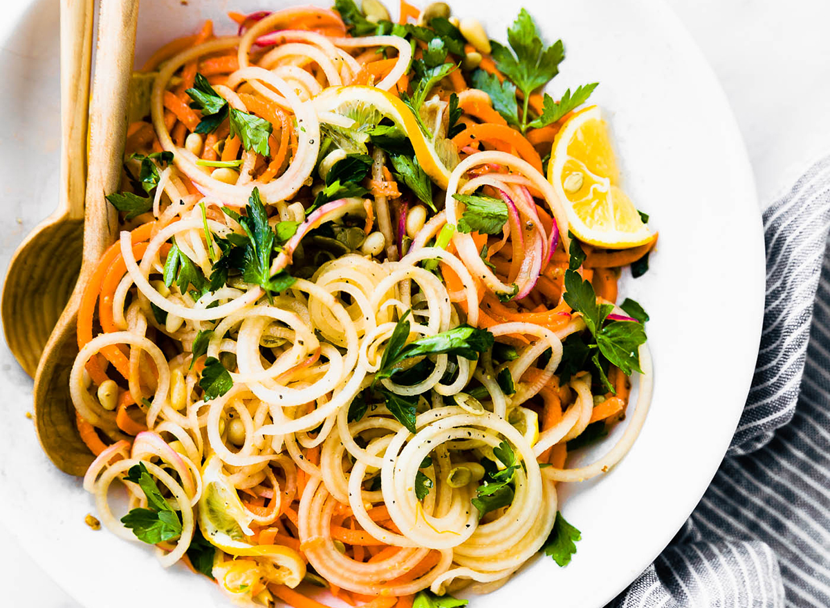 celeriac carrot salad spiralized into a noddle bowl that is vegan and paleo