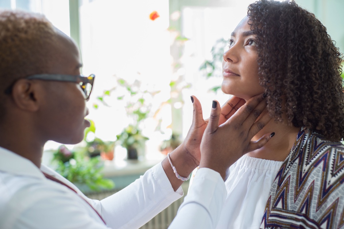 doctor examines with her fingers, palpates her neck and lymph nodes