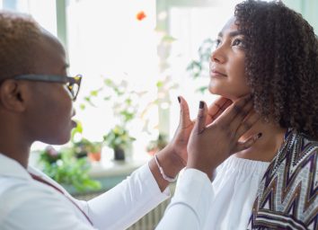 doctor examines with her fingers, palpates her neck and lymph nodes