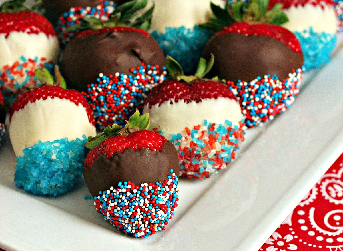 white and milk chocolate covered strawberries with red white and blue sprinkles on white serving platter
