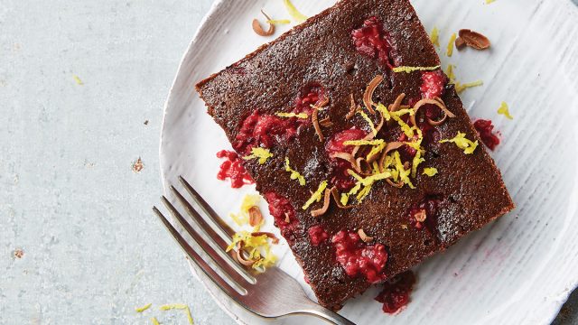 fudgy raspberry brownie on white plate with fork