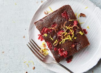 fudgy raspberry brownie on white plate with fork