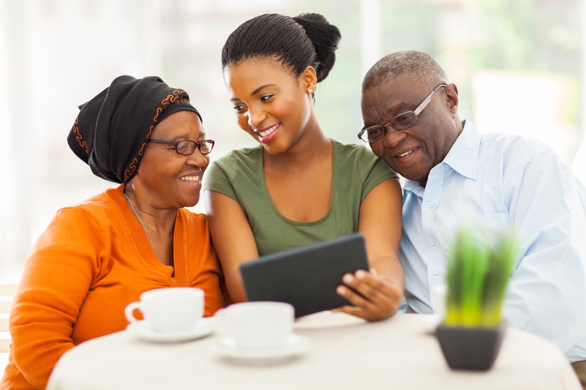 cheerful african family at home using tablet