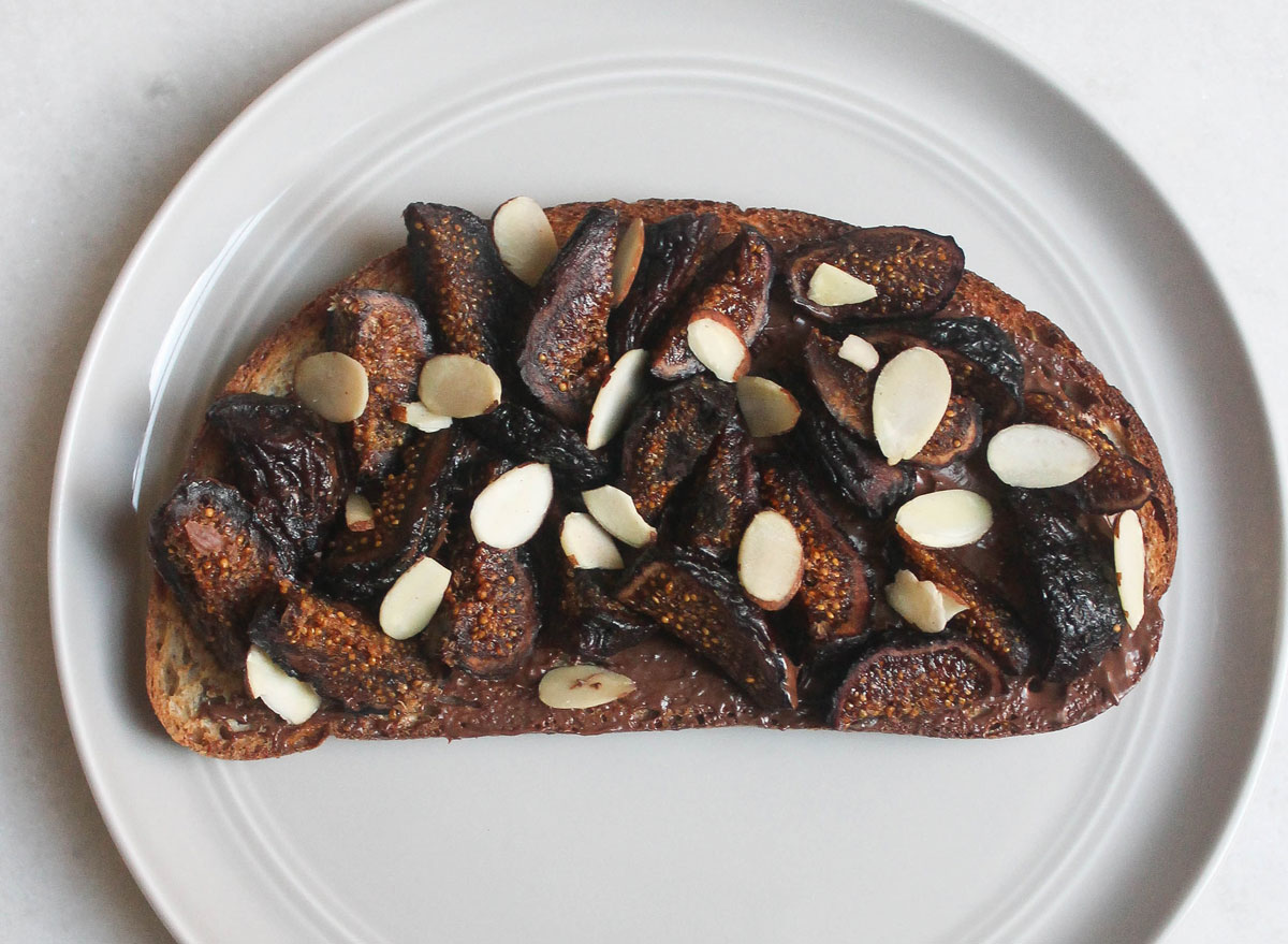 hazelnut spread fig almonds toast on grey plate marble counter