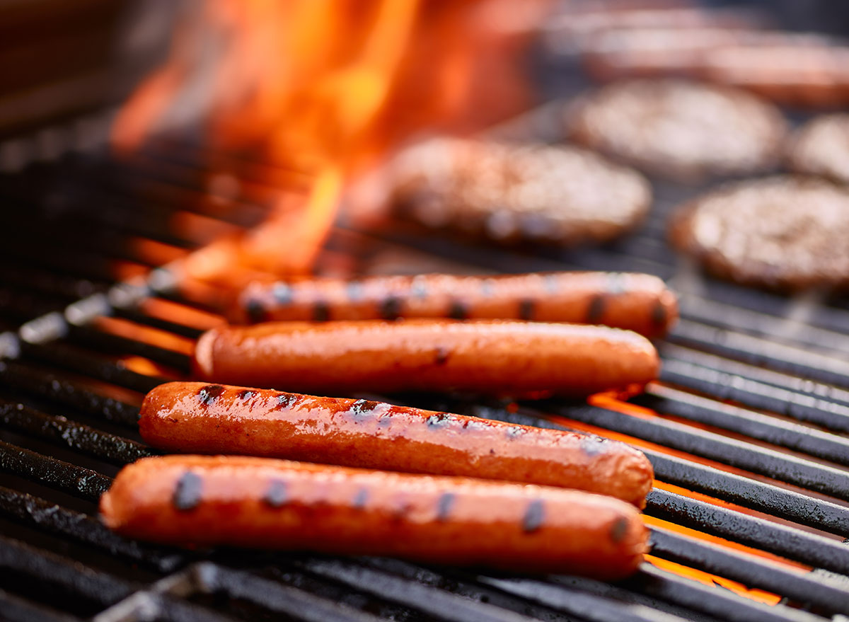 hot dogs burgers on flaming grill