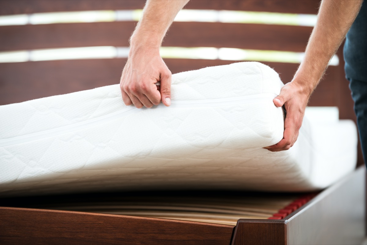 Close up photo of young man demonstrating quality of mattress.