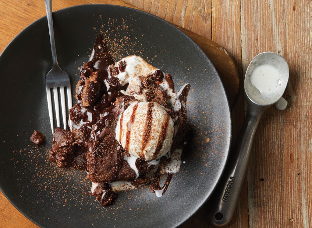 pastel de chocolate de lava fundida con yogur helado y cuchara en placa negra