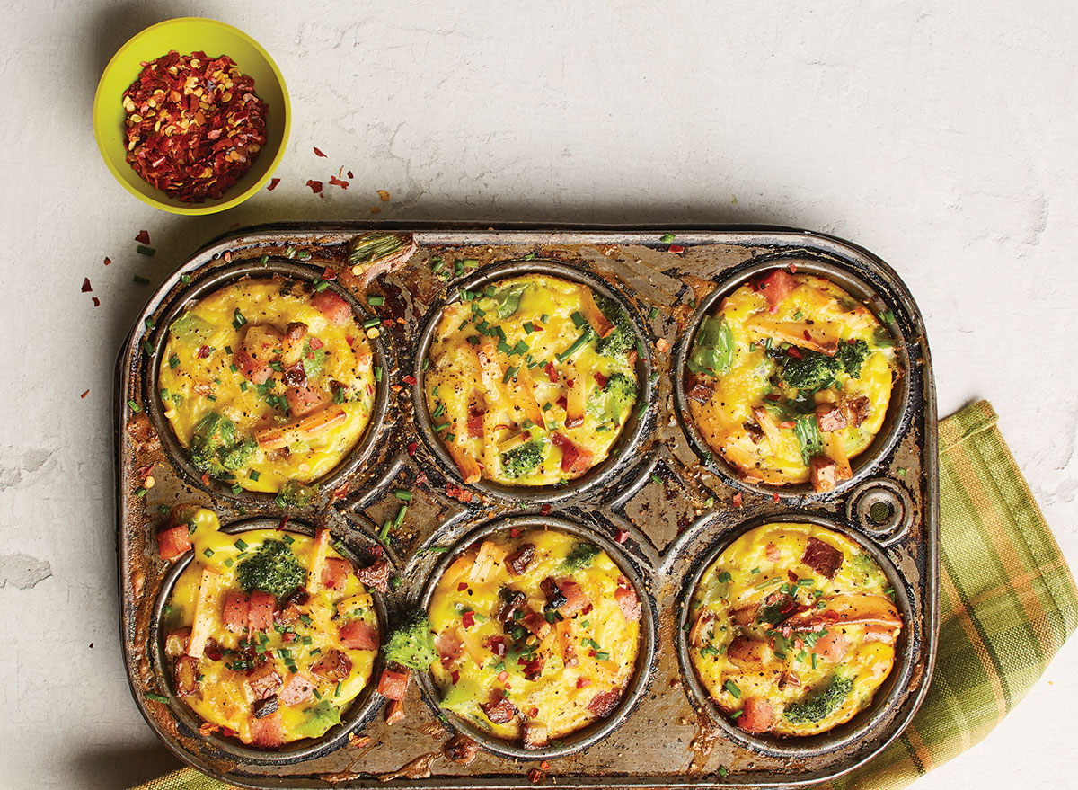 quiches with smoked gouda and ham on muffin tin with dish cloth and dried chili peppers