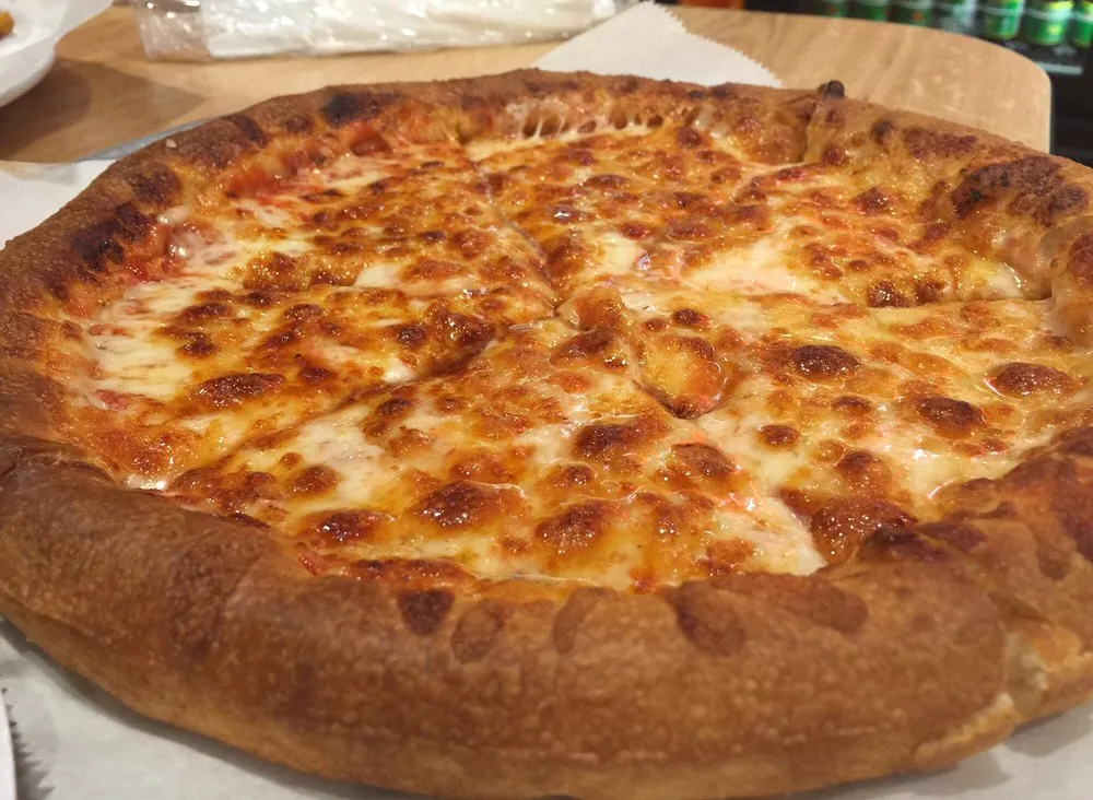 greek style pizza with large crust and lots of cheese on top