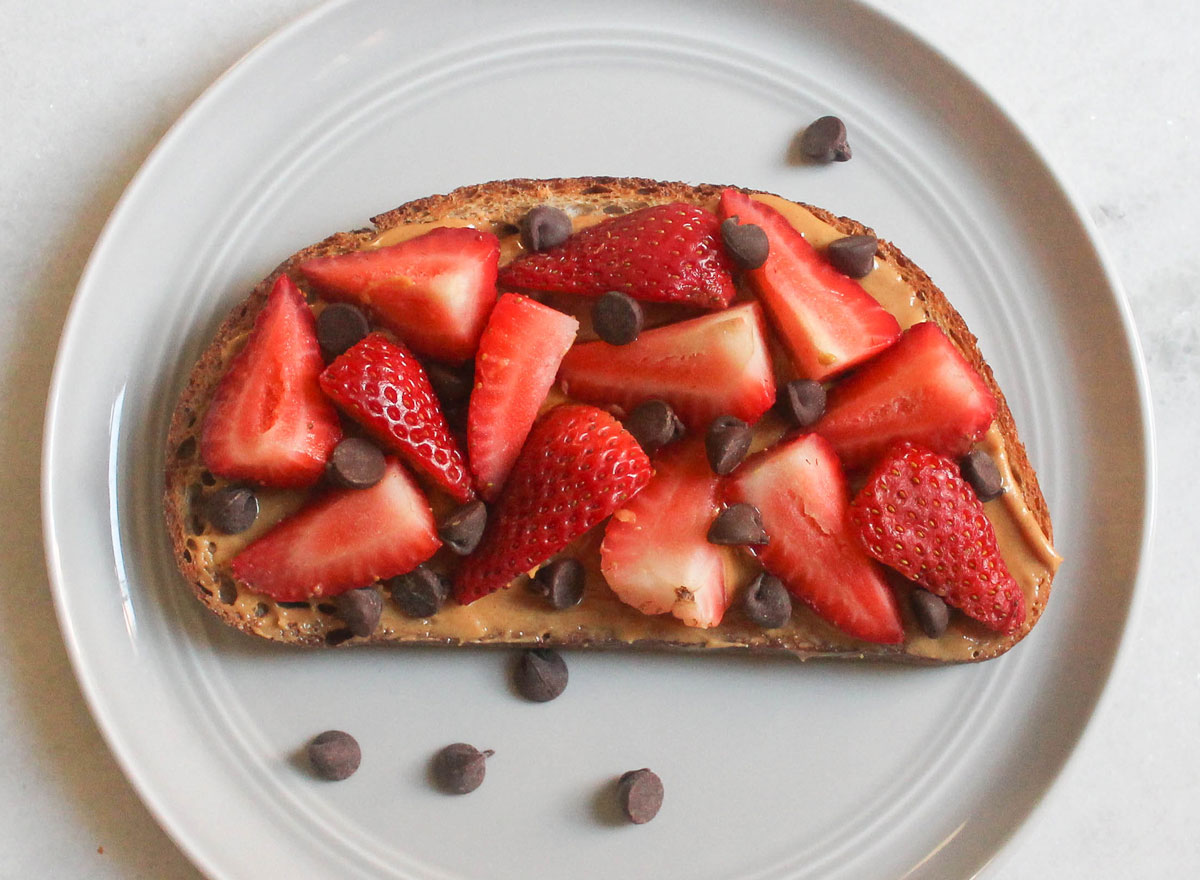 peanut butter strawberry chocolate chip toast on grey plate and marble counter