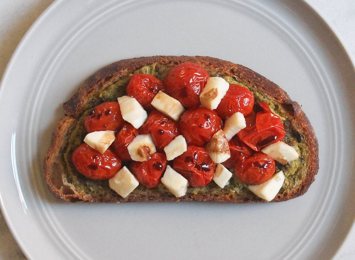 pesto roasted tomatoes mozzarella balsamic toast on grey plate and marble counter