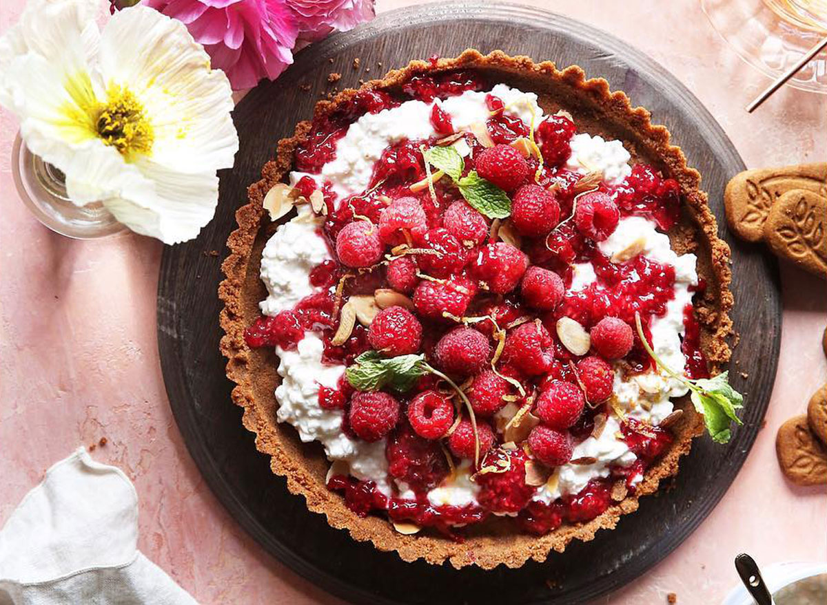 raspberry and cottage cheese tart on a pink table with flowers