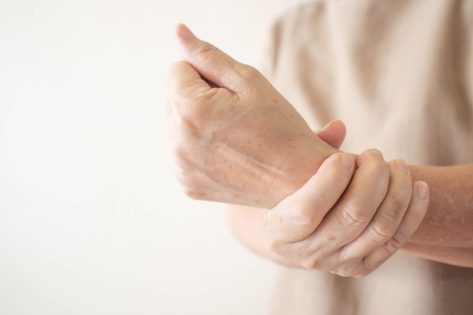 senior woman holding wrist with joint pain poor bone health