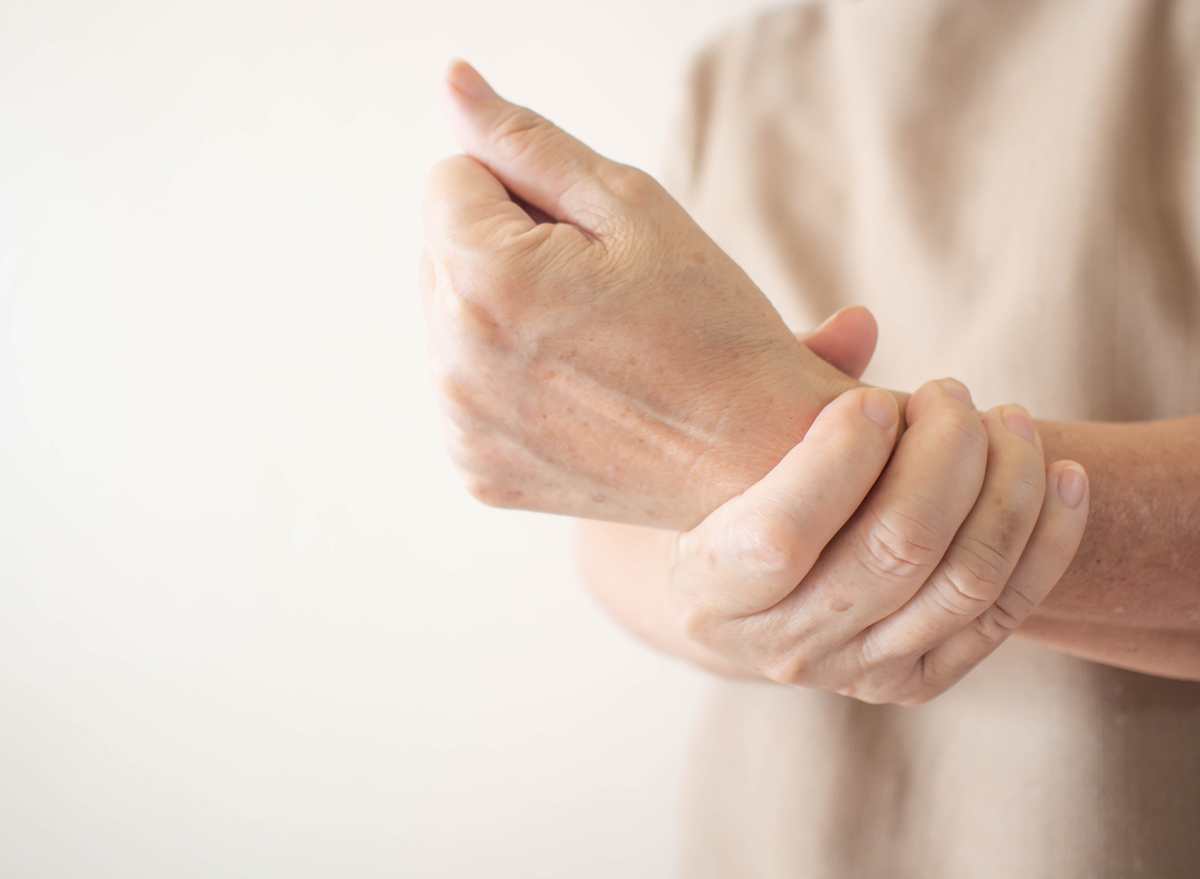 senior woman holding wrist with joint pain poor bone health