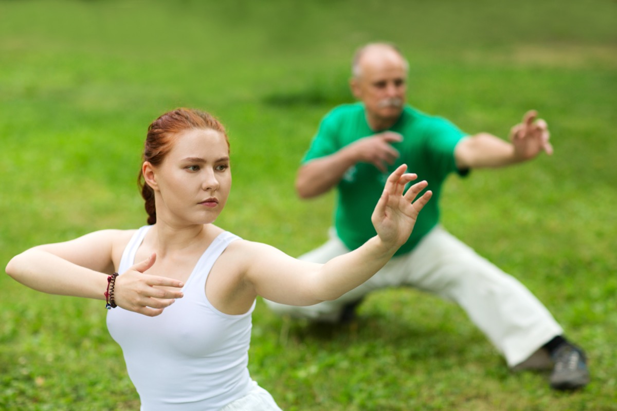 group of people practice Tai Chi Chuan in a park