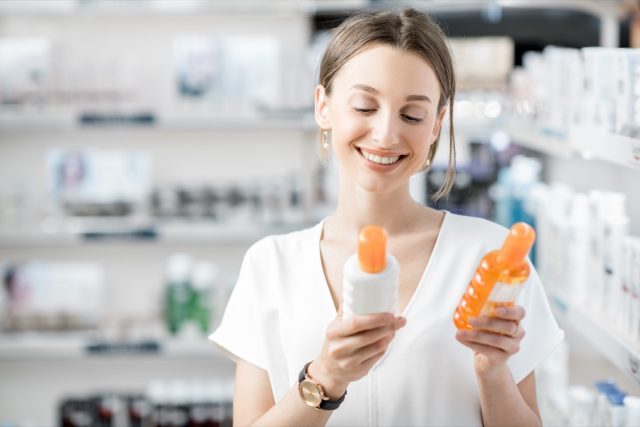 woman customer choosing sunscreen lotion at the pharmacy store