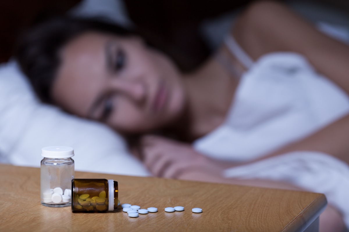 woman next to sleeping pills