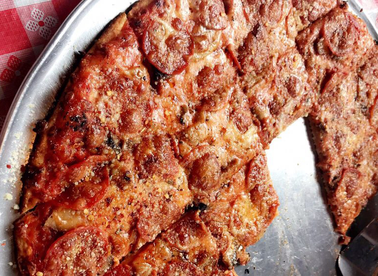 st. louis style pizza cut in squares on a table with a red picnic blanket