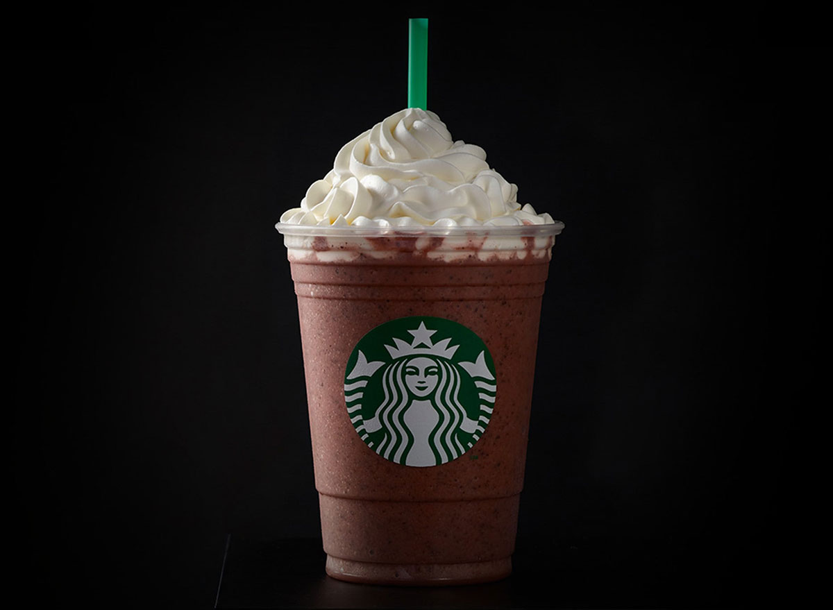 starbucks red velvet frappuccino with green straw on black background