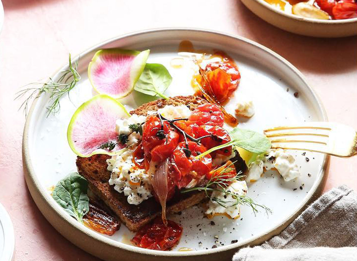 tomato confit toast with cottage cheese on a plate with flowers