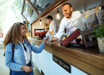 woman buying potatoes from a food truck