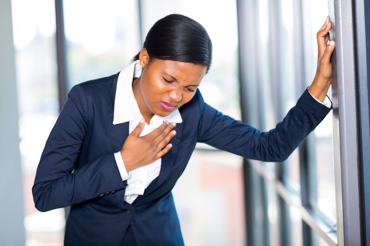 young african american businesswoman having heart attack or chest pain
