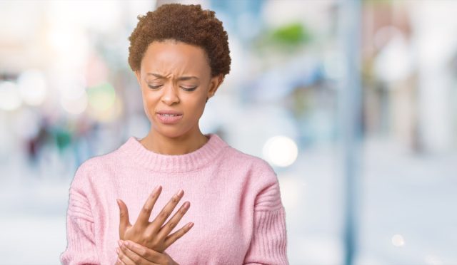 young african american woman over isolated background Suffering pain on hands and fingers, arthritis inflammation