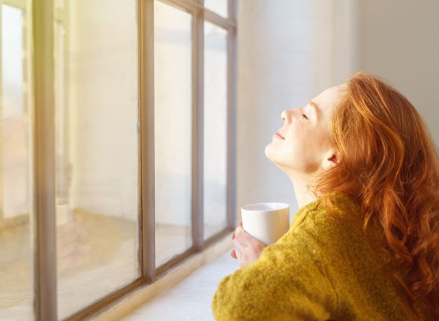 happy woman sitting by the window