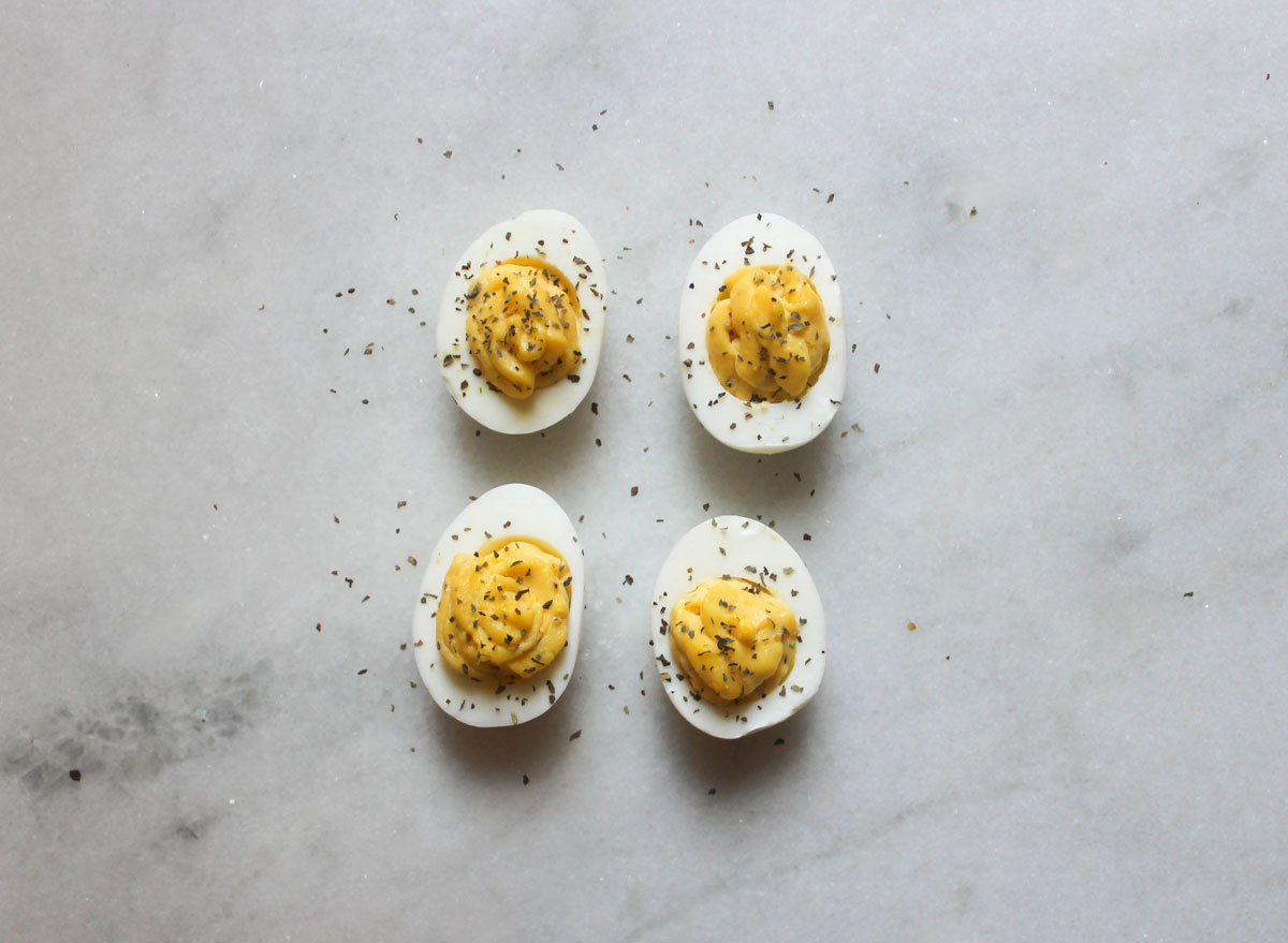 garlic basil deviled eggs on a marble counter
