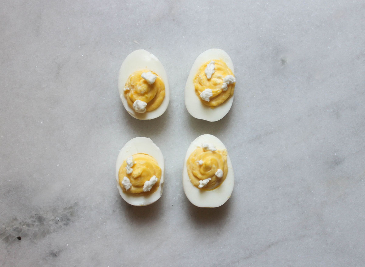 goat cheese deviled eggs on a marble counter