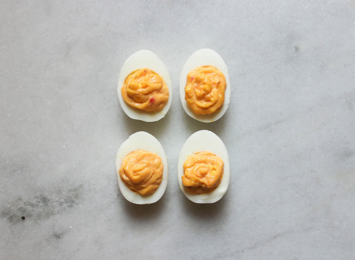 pimento cheese deviled eggs on a marble counter