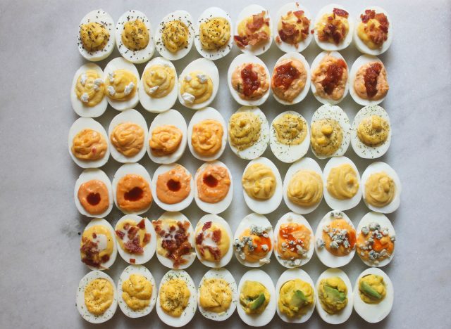 numerous deviled egg combinations all on a marble counter