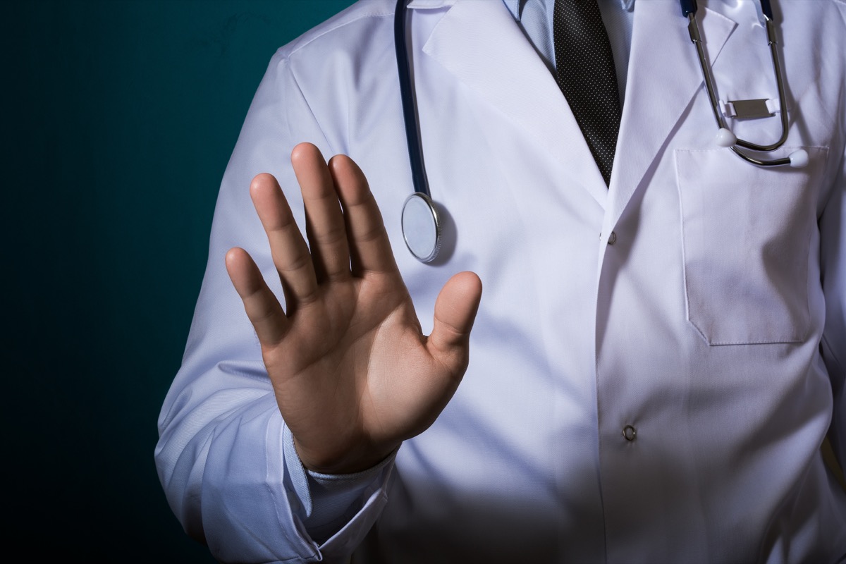The doctor shows a "stop" gesture
