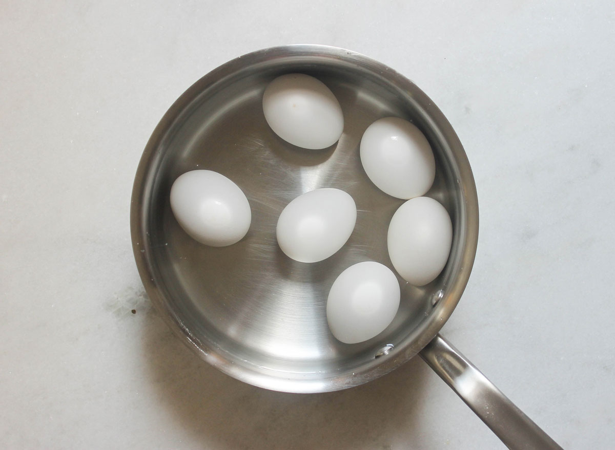 eggs in a pot covered in water before boiling