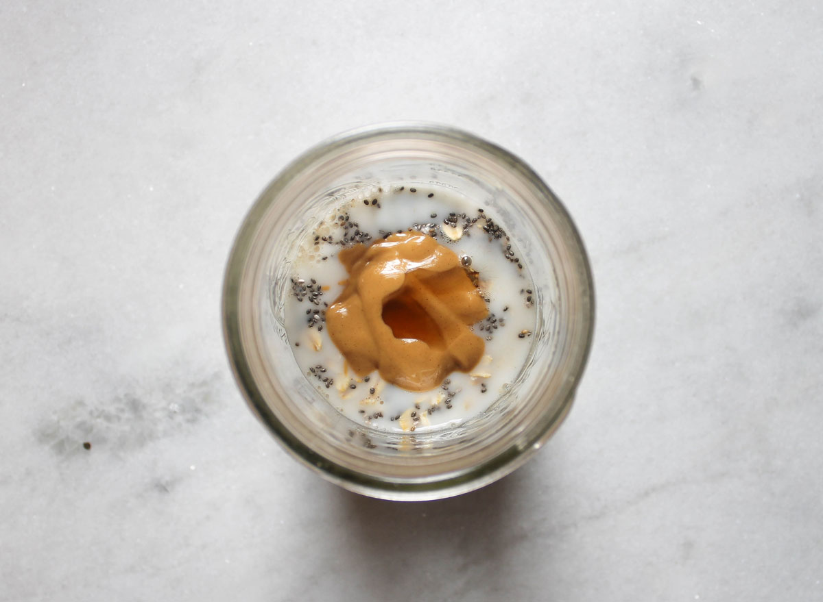 overnight oats ingredients not mixed in a jar on a marble counter