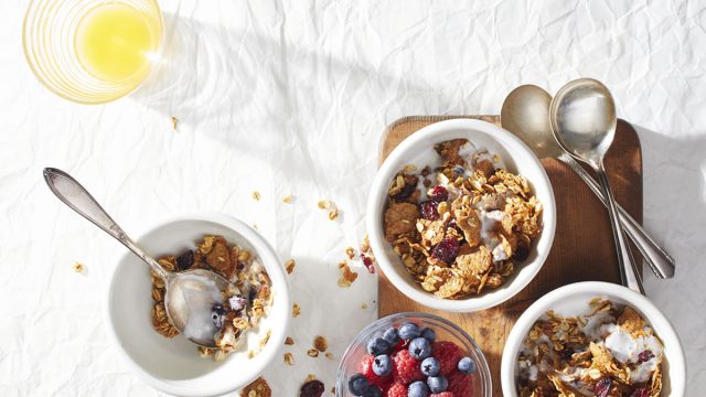 cranberry orange granola bowls with bowl of berries and spoons