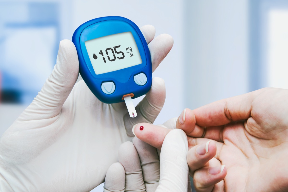 Doctor making blood sugar test in clinic for diabetes