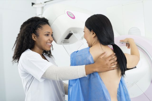 Doctor Assisting Woman Undergoing Mammogram X-ray Test