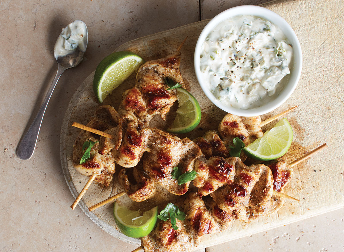 garam masala chicken skewers with dip on wood serving board