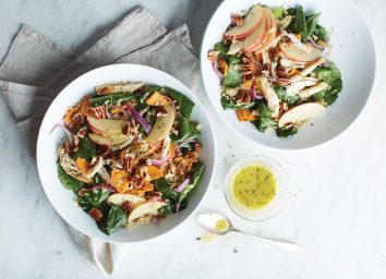 kale quinoa salad with apples and walnuts in two white bowls