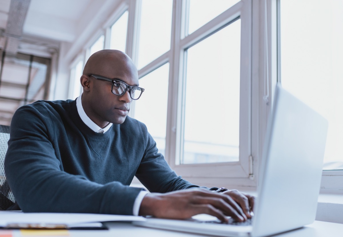 businessman working on his laptop. Handsome young man at his desk