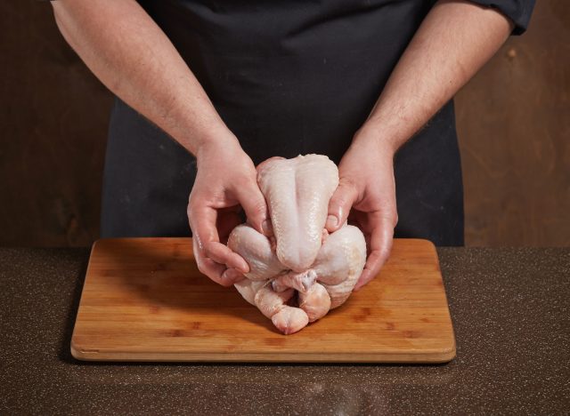 man preparing raw chicken