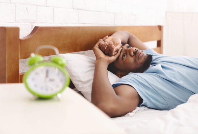 Man in bed suffering from insomnia